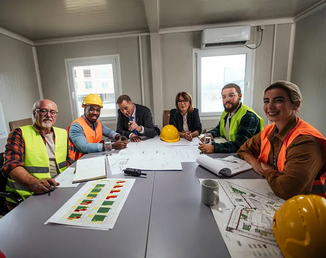 Construction team reviewing blueprints in office