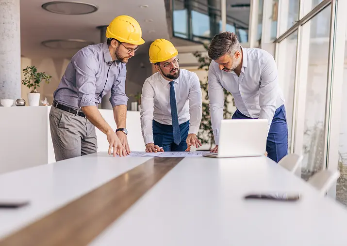 Engineers reviewing plans in modern office